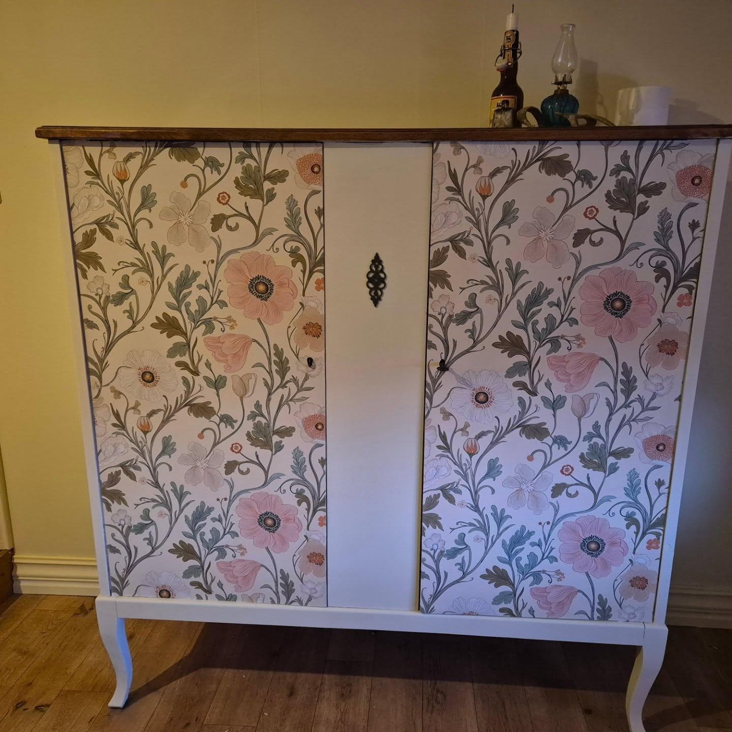 Fick lite feeling när jag målade på övervåningen, så de bruna linneskåpet fick samma färg som väggarna. Så kom jag på att jag fick 2 små bitar av tapeten över, så den kom till användning på dörrarna. Toppskivan fick behålla sin färg, bryter av ganska fint. 
Sen skulle jag kasta ett sängbord som min mamma köpte för över 40 år sedan och det var sån fin smidesgrej på lådan, så den pillade jag lös och satte på mittenbrädan, blev som pricken över i:et tycker jag 😊 Återbruk när det är som bäst! 

#kulörkompisar #återbruk #gördetsjälv #gammaltmöternytt #gultärintefult